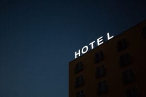 neon "HOTEL" sign on top of a building at nighttime